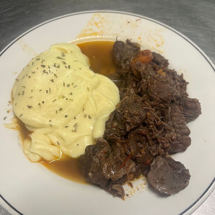 Carne guisada con su crema de patata al lado