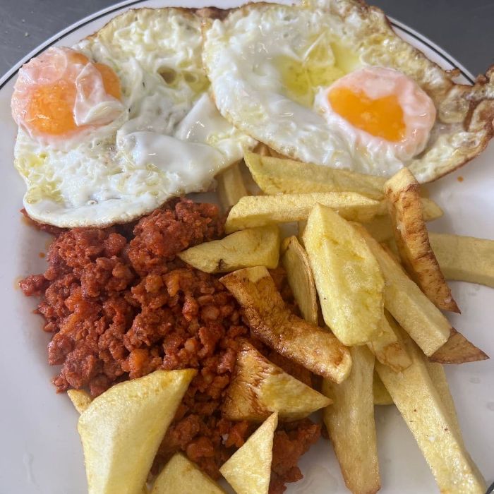 Picadillo con dos huevos fritos y patatas